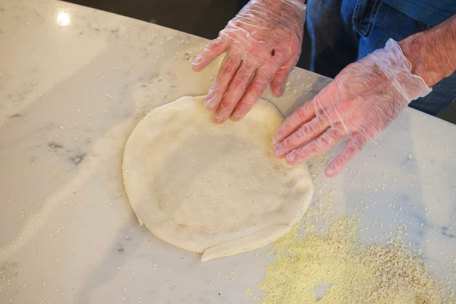 Hands stretching fresh pizza dough by hand